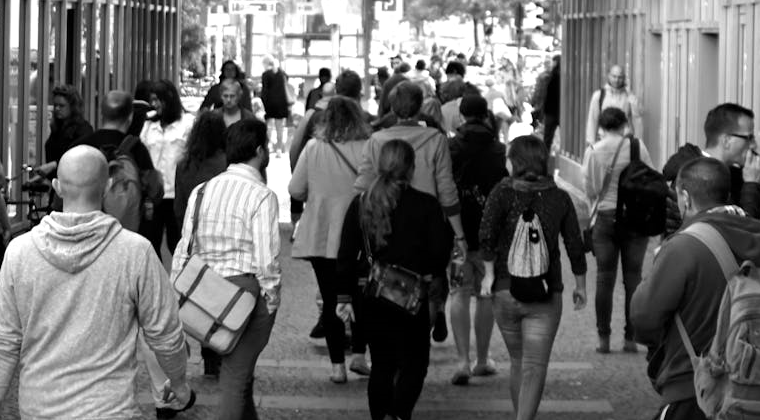 Black and white photo of busy pedestrian walkway.